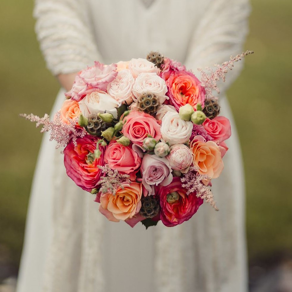 Круглый оранжевый букет невесты с пионовидными розами