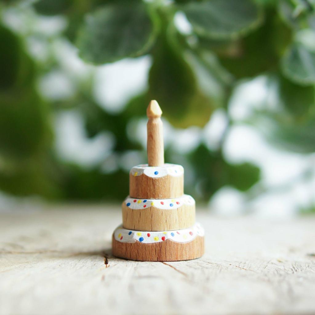 Wooden cake with sprinkles and with candle