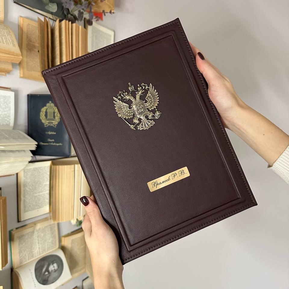Именной ежедневник А4 с натуральной кожей, гербом России, гравировкой имени и золотым обрезом. Внутри — бархатные карманы и держатель для ручки. Идеальный подарок для руководителей и государственных служащих.
