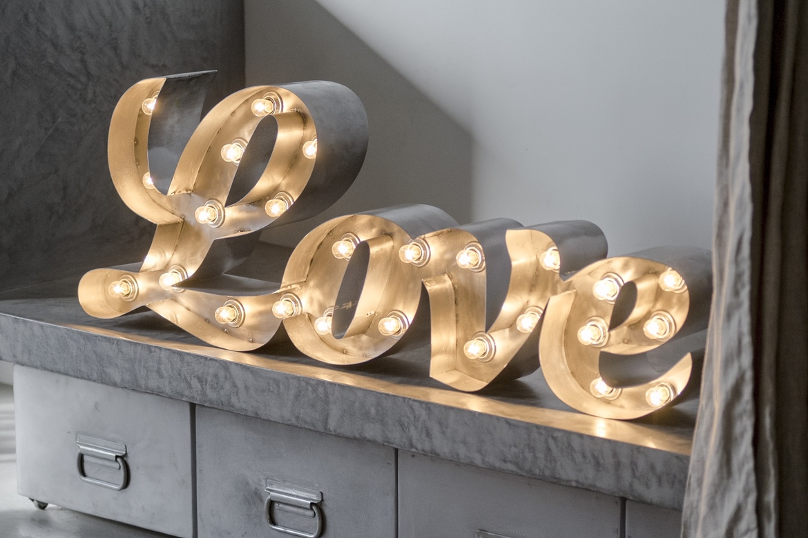 Слово Love из стали с лампами