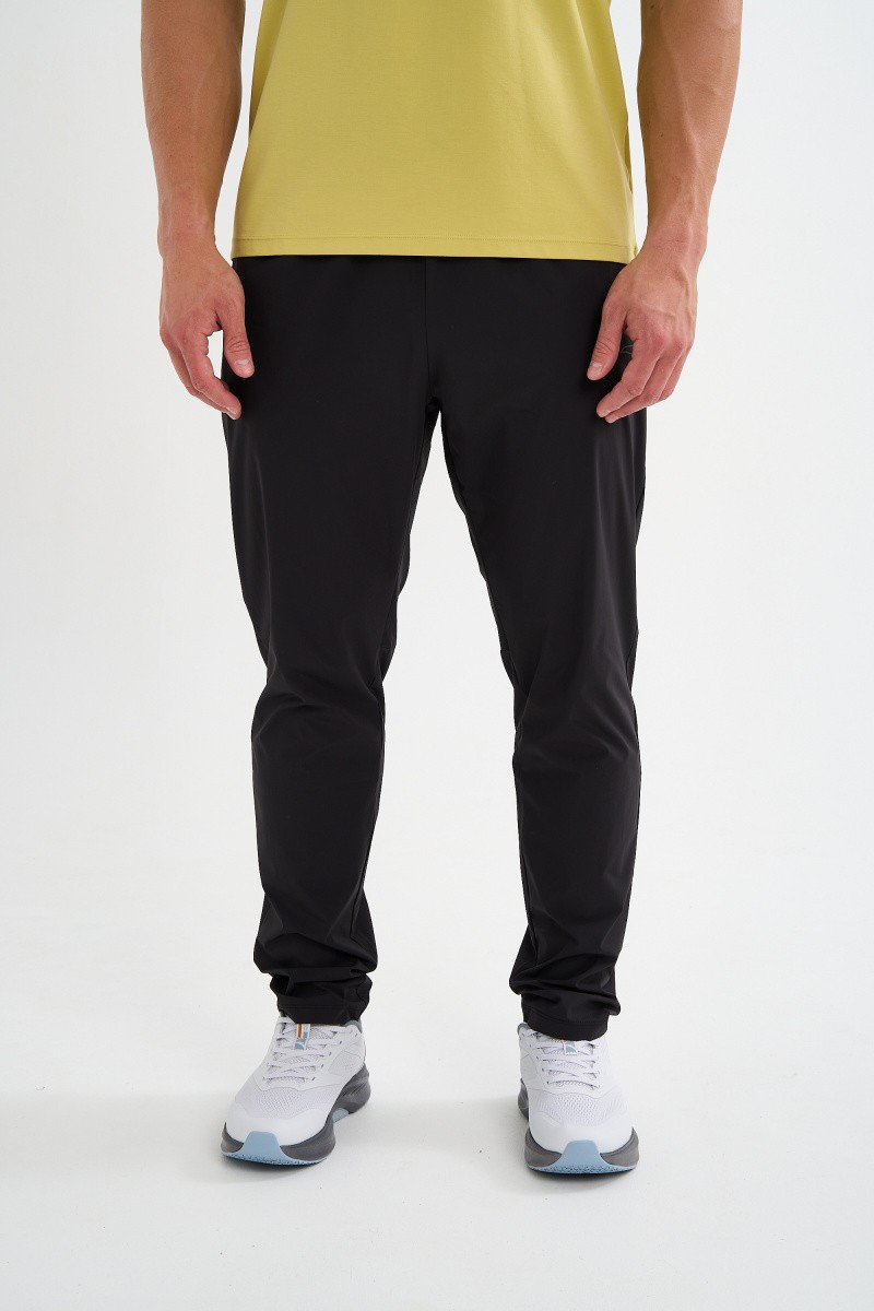 БРЮКИ ТЕКСТИЛЬНЫЕ УДЛИНЕННЫЕ ANTA RUNNING WOVEN TRACK PANTS