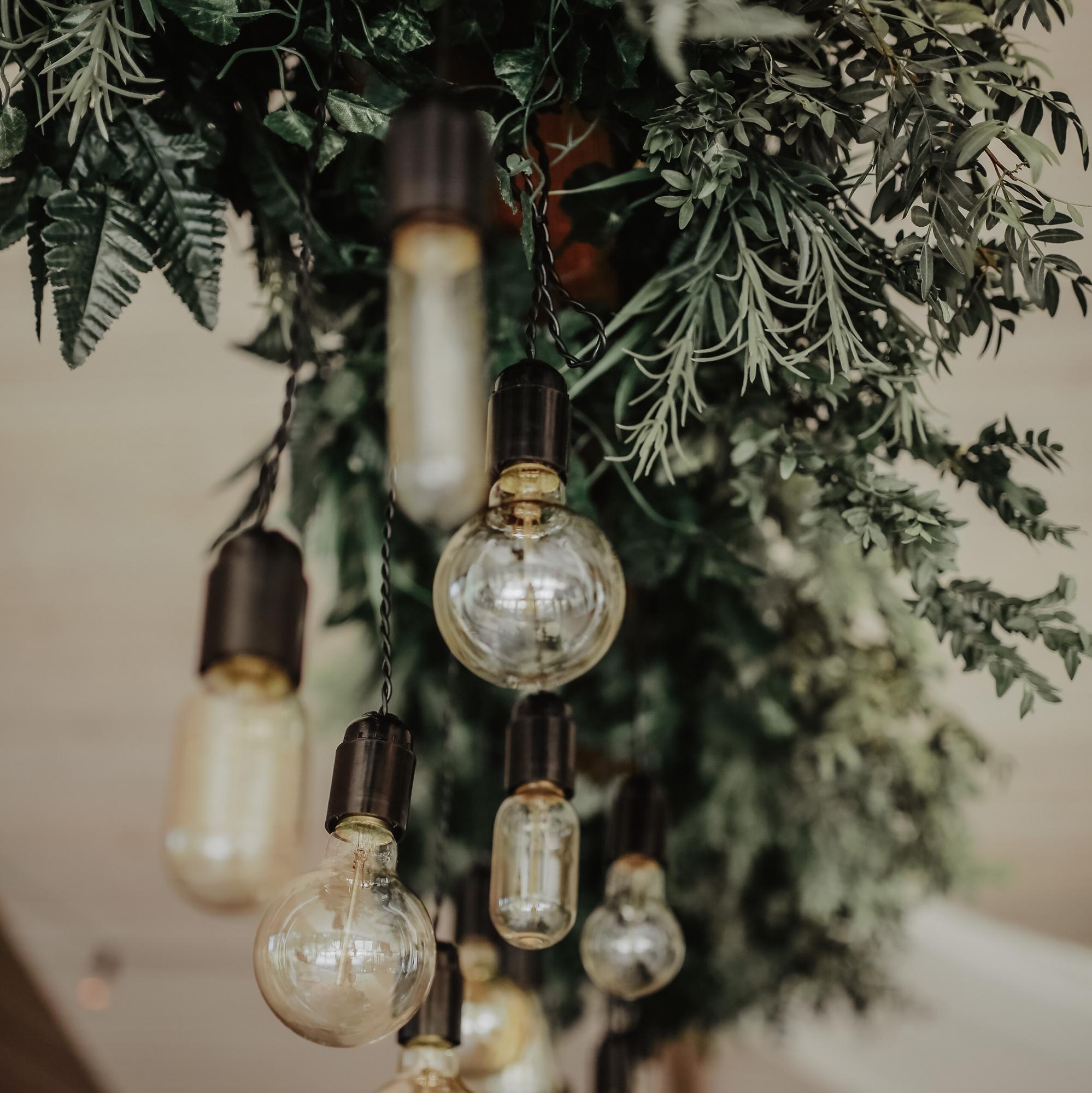 Люстра на доске, декорированная зеленью