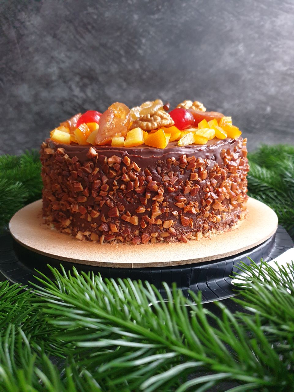 Большой круглый рождественский кекс в шоколадном покрытии с сухофруктами