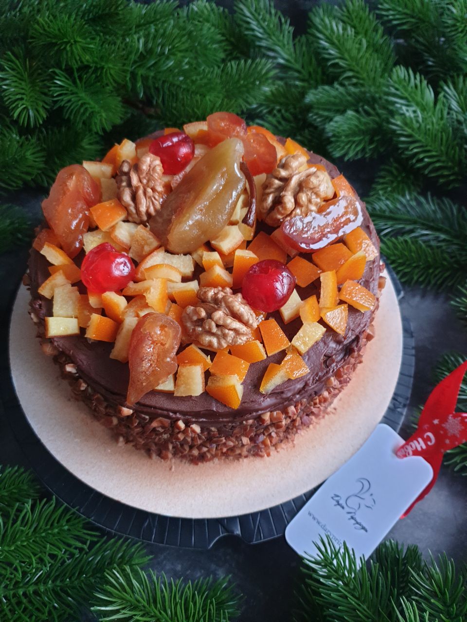 Большой круглый рождественский кекс в шоколадном покрытии с сухофруктами