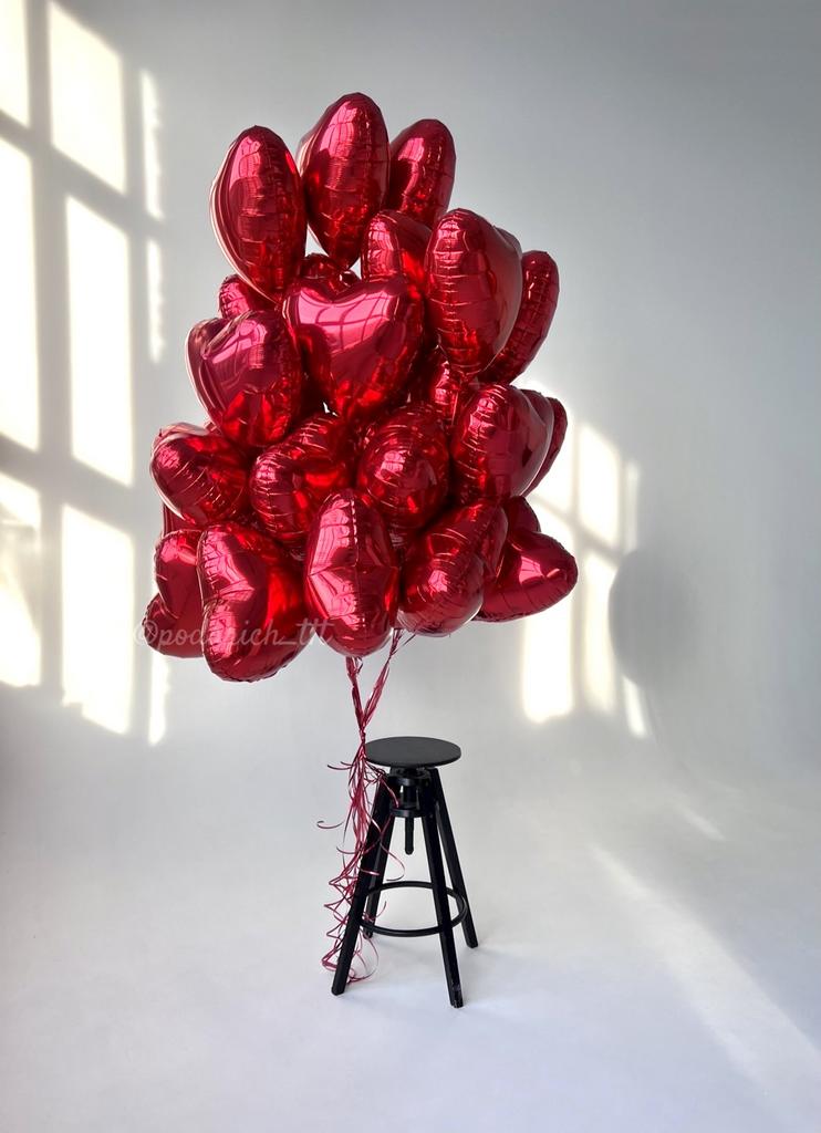 фото большое количество шариков-красных сердец фольгированных ,привязанных к стулу