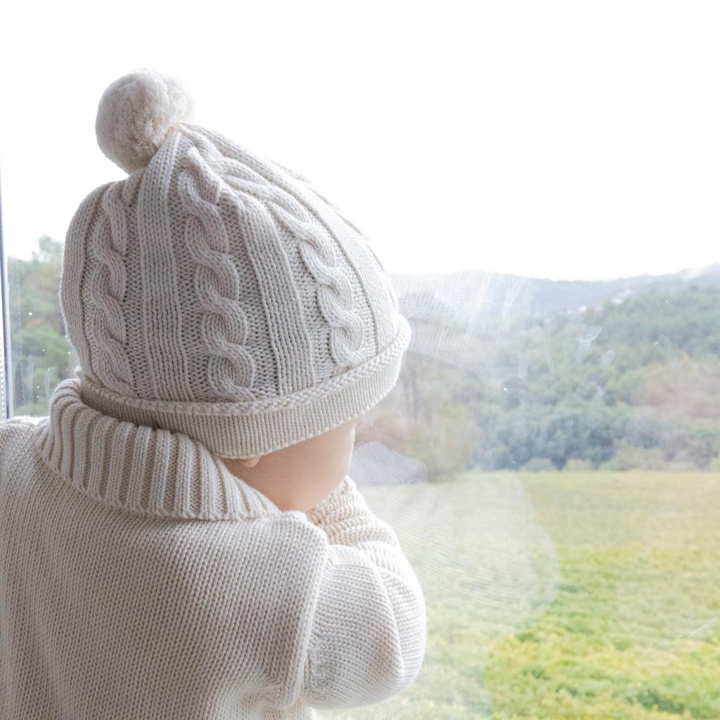Вязаная шапка с отделкой косами и помпоном