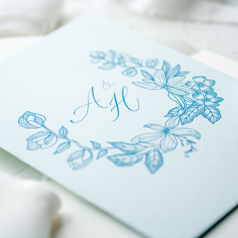 Приглашение с цветочной монограммой на голубой бумаге