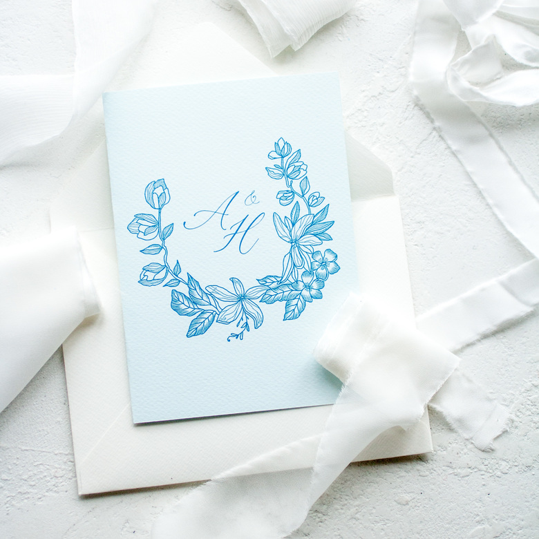 Приглашение с цветочной монограммой на голубой бумаге
