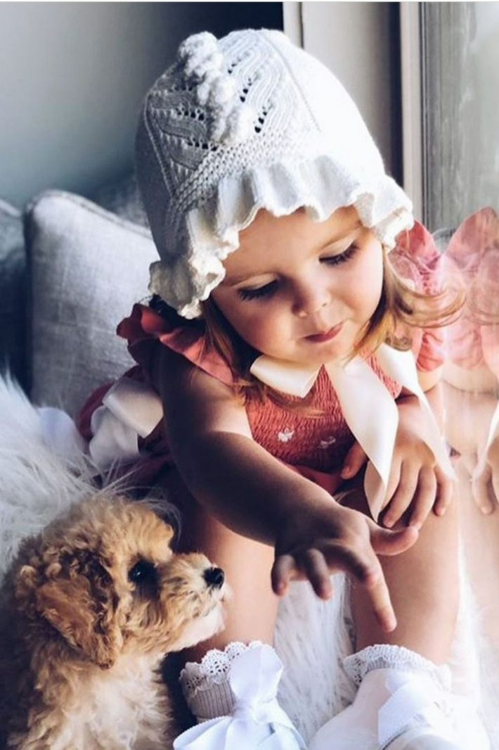 Белый вязаный чепчик на девочке