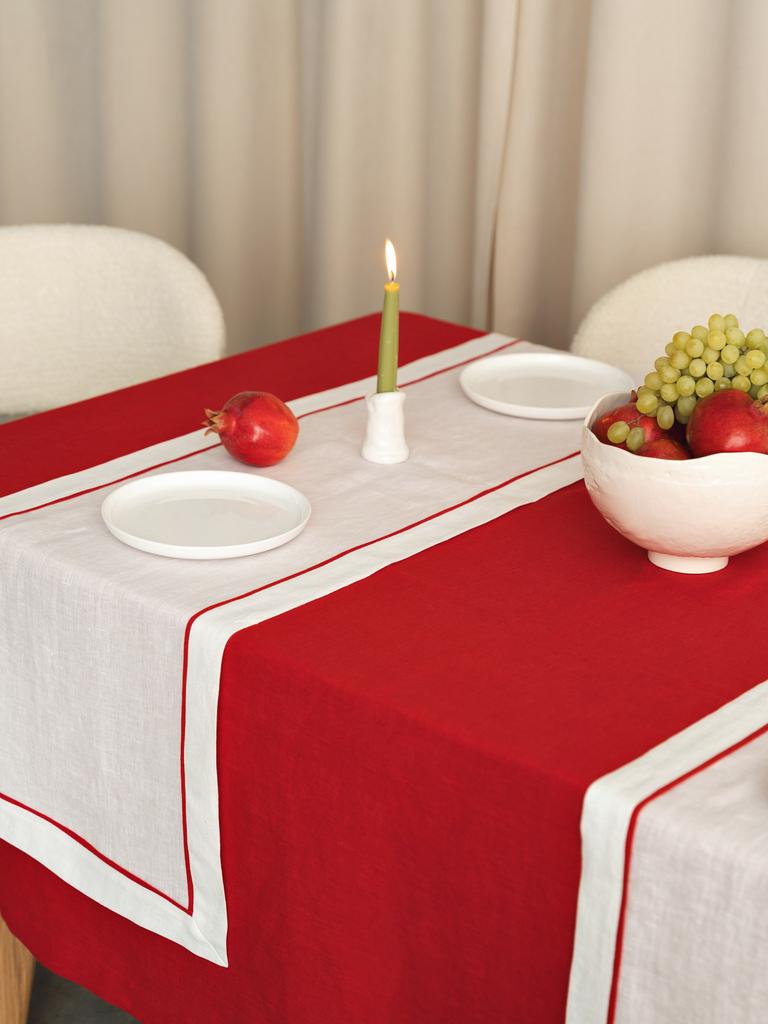Льняной раннер молочного цвета с красным кантом на праздничном столе, сервировка с новогодним настроением