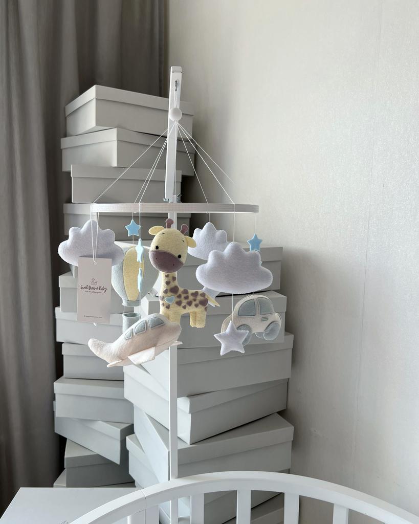 Мобиль с жирафом, воздушным шаром, машинкой и самолётом.