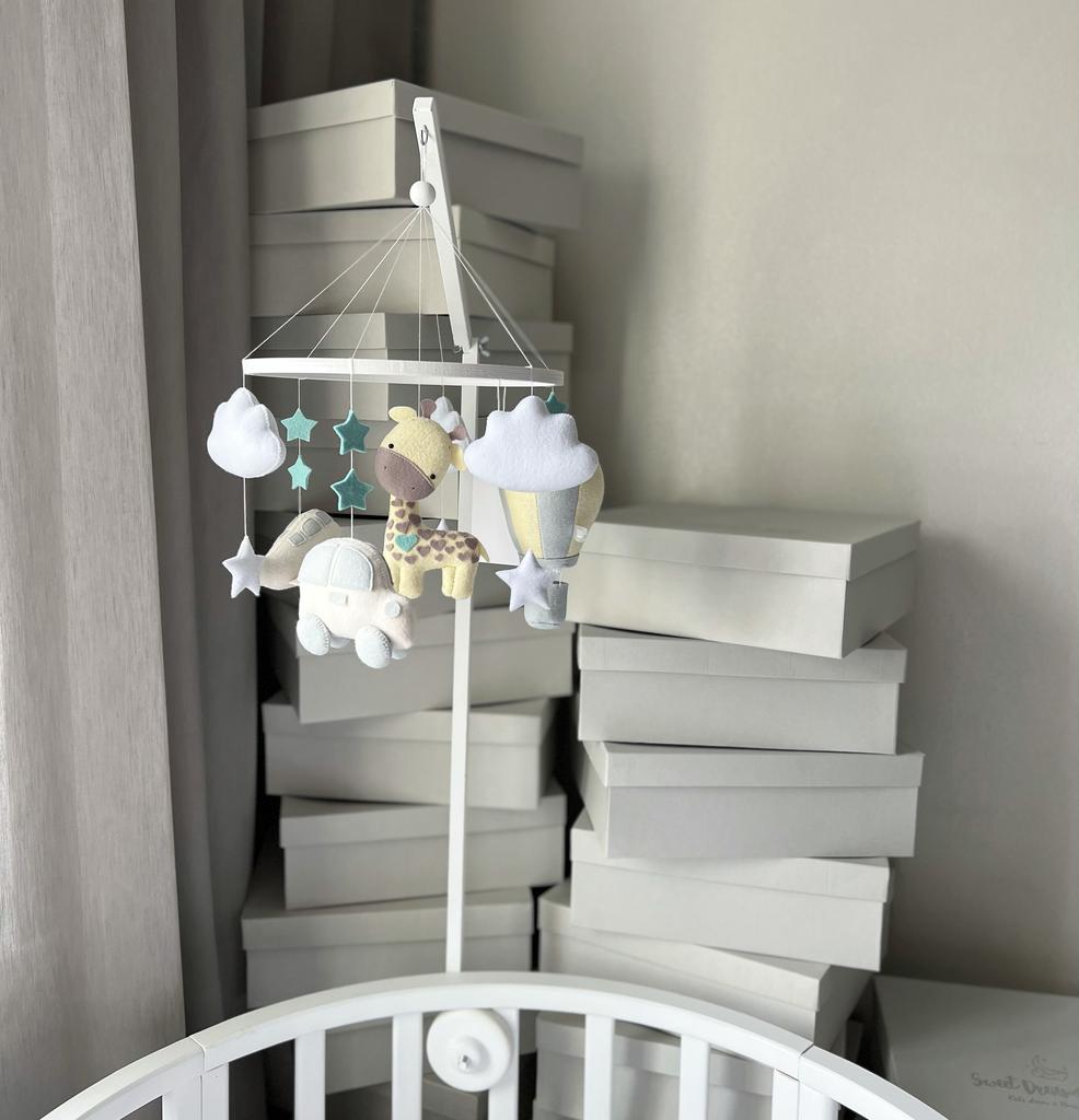 Мобиль с жирафом, воздушным шаром, машинкой и самолётом.