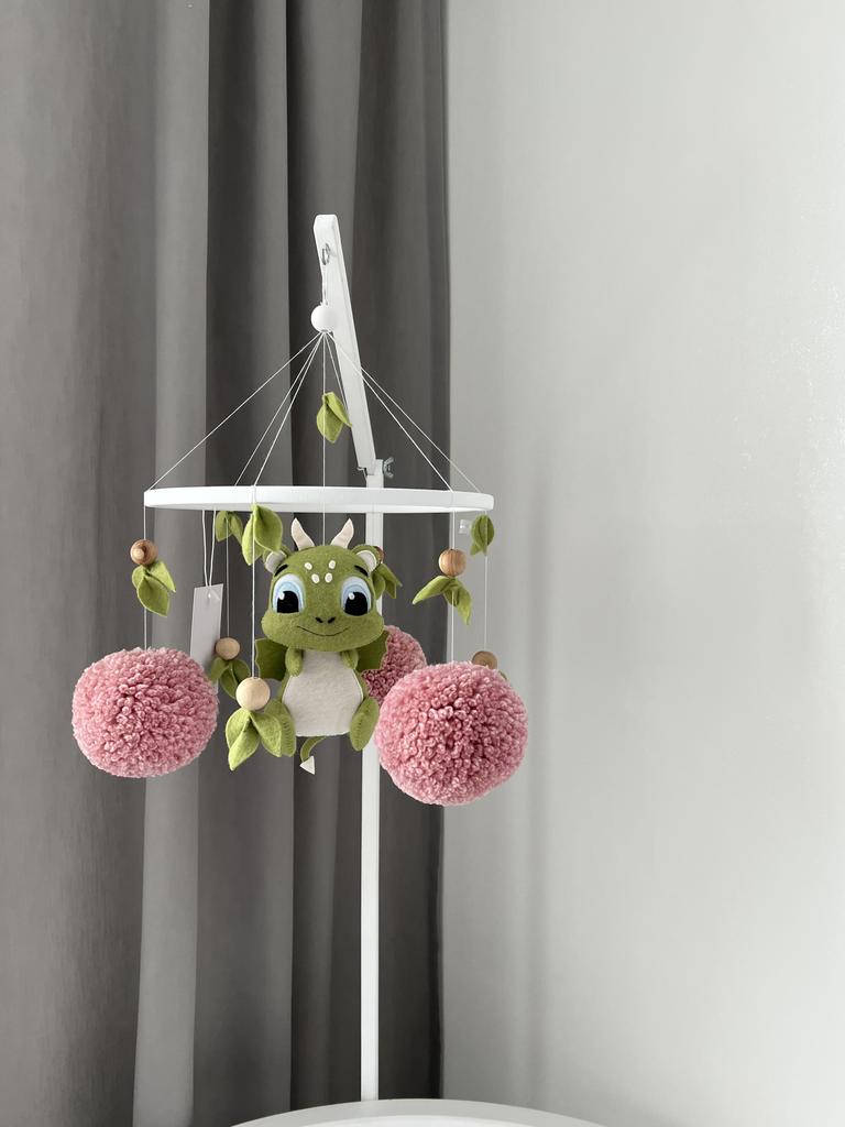 Мобиль дракончик с розовыми помпонами.