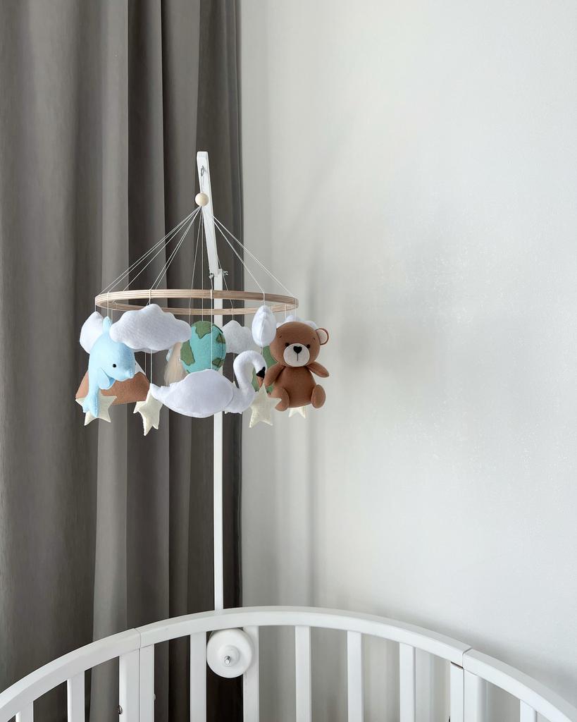 Мобиль с лошадкой, горами, ёлочкой, мишкой, лебедем, дельфином и планетой.