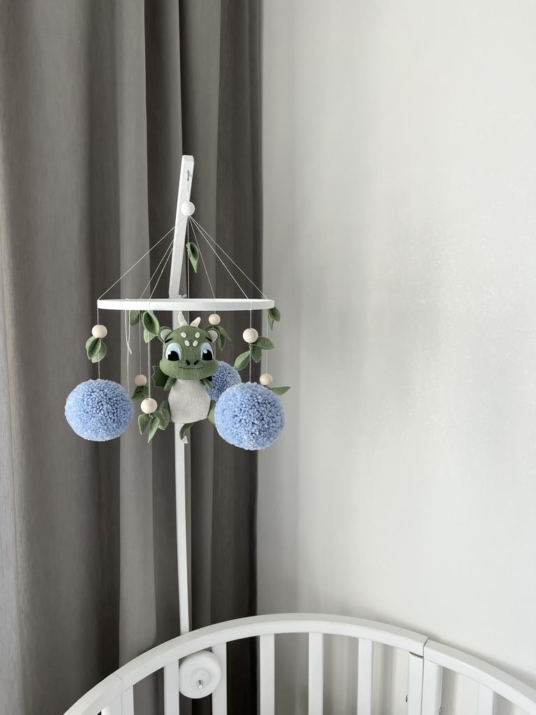 Мобиль дракончик с голубыми помпонами.
