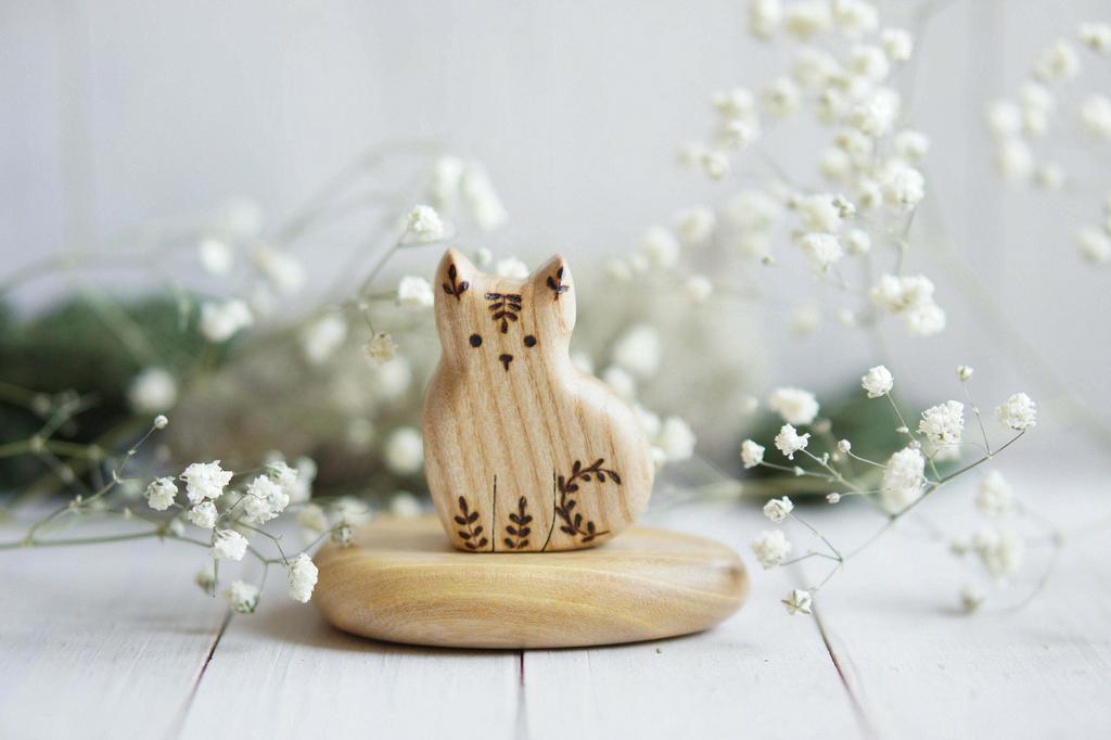 Cat sitting wooden toy flower