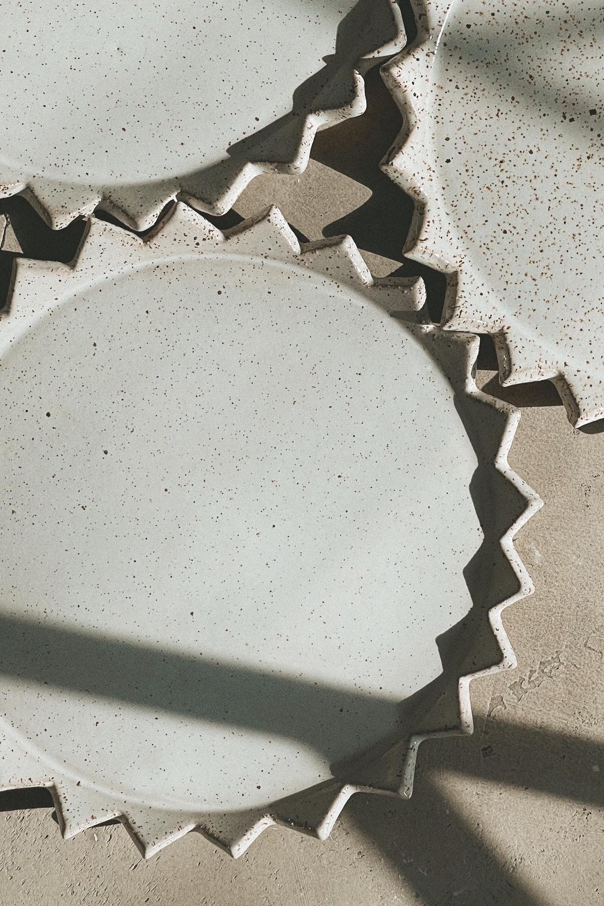 Белая тарелка в крапинку в виде солнца