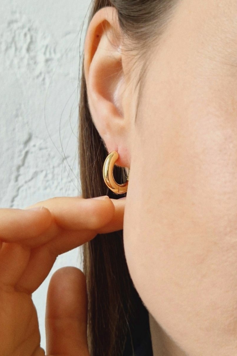 базовые серьги конго золотистого цвета на женском ухе