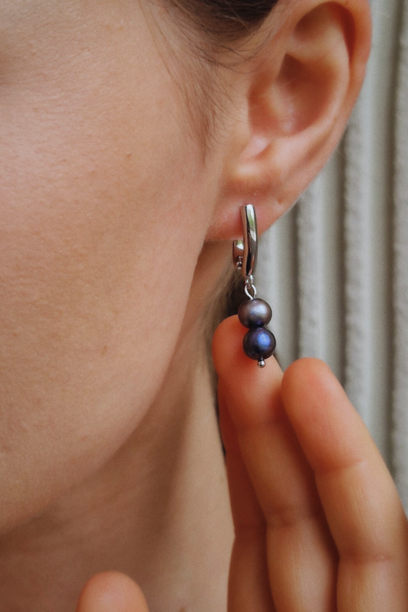 серьги с черным жемчугом на женском ухе
