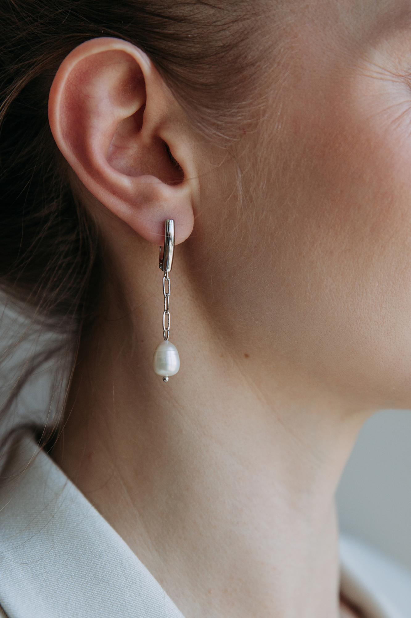 сережки с жемчугом на цепочке на женском ухе
