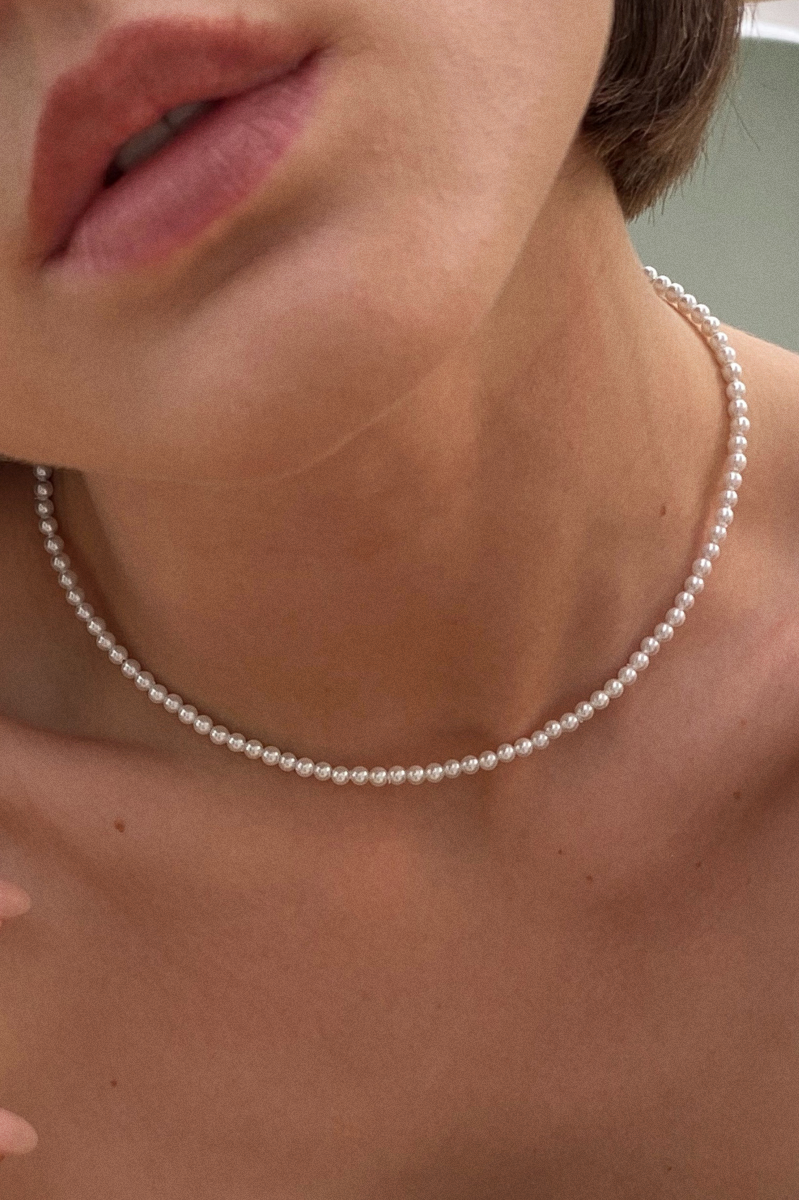 короткий чокер из мелкого жемчуга на женской шее