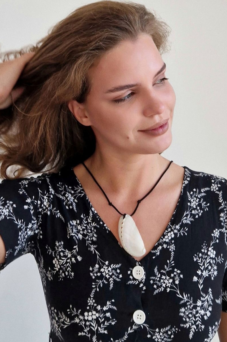 ракушка на шнурке на шее у девушки