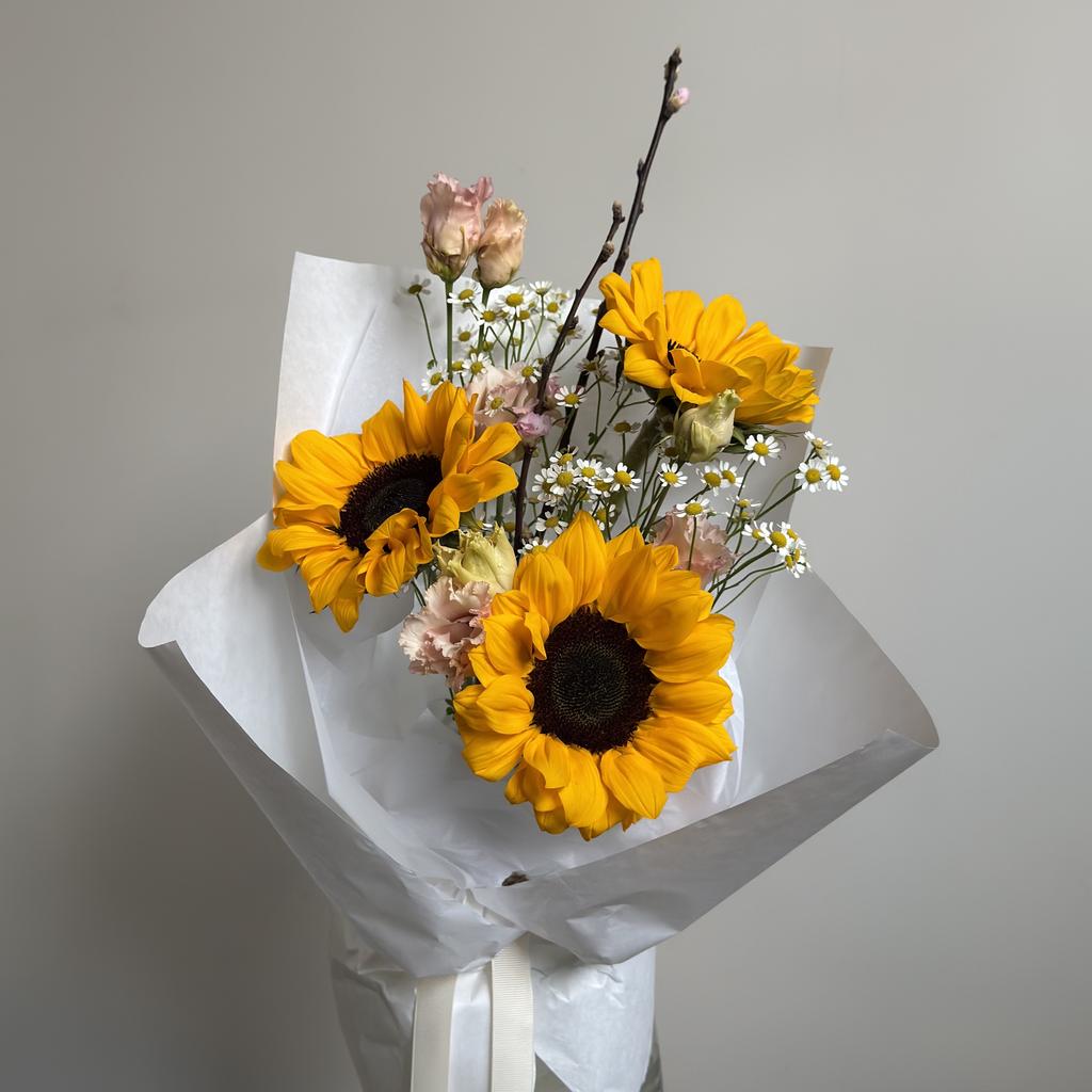 Букет с подсолнухами и цветущими ветками прунуса