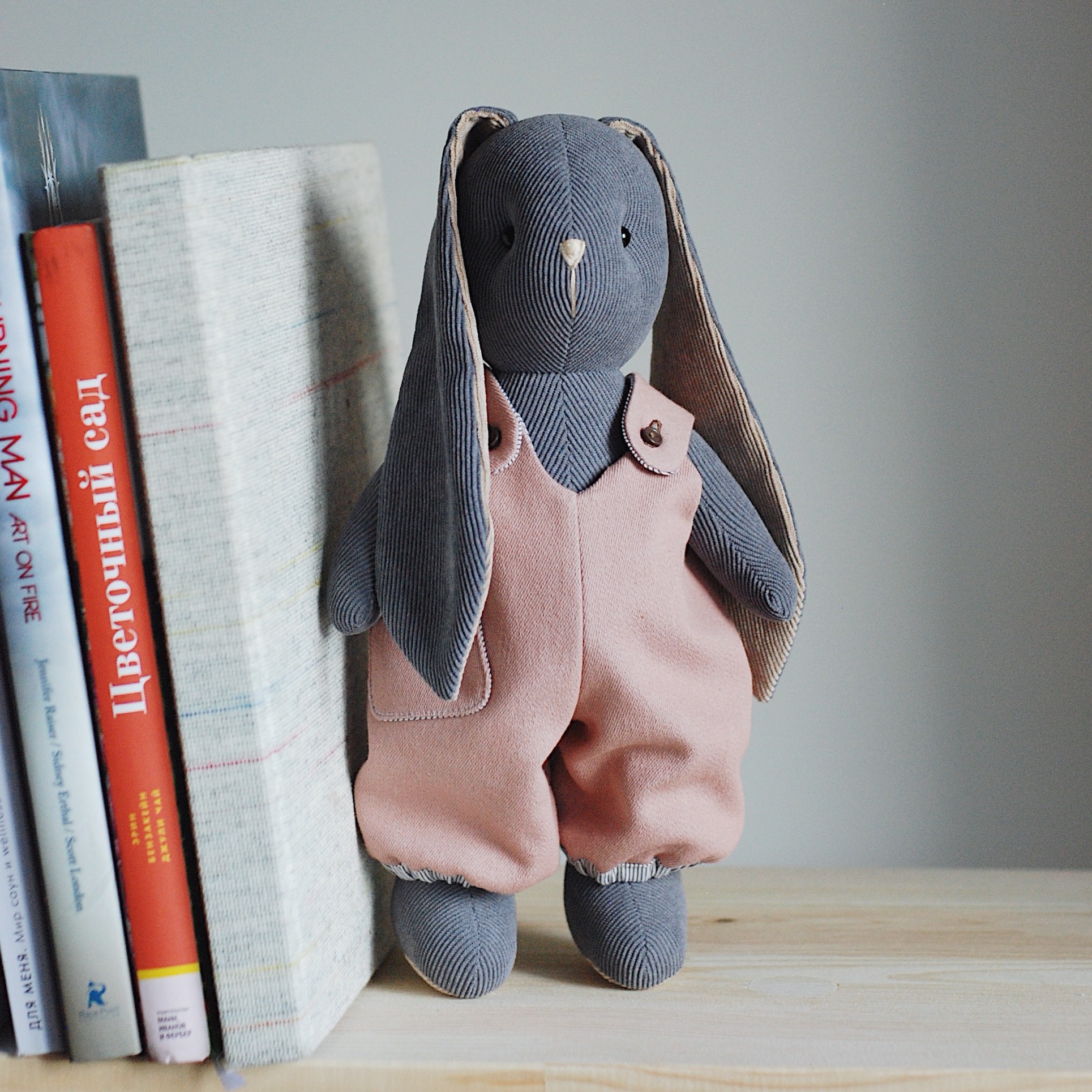 Светло-серая зайка в розовом комбинезоне