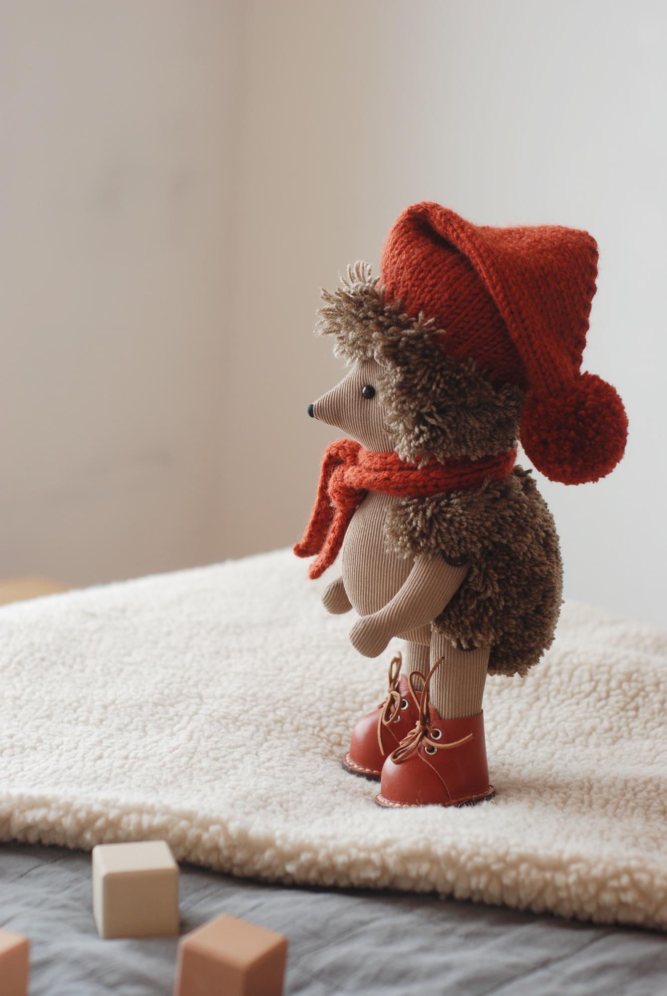 Темно-бежевый ежик в ботинках и шапке с шарфом