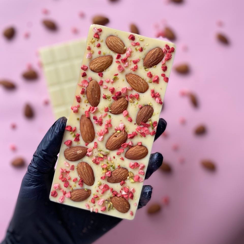 Плитка белого шоколада с цельным миндалем, сублимированной клубникой и фисташкой