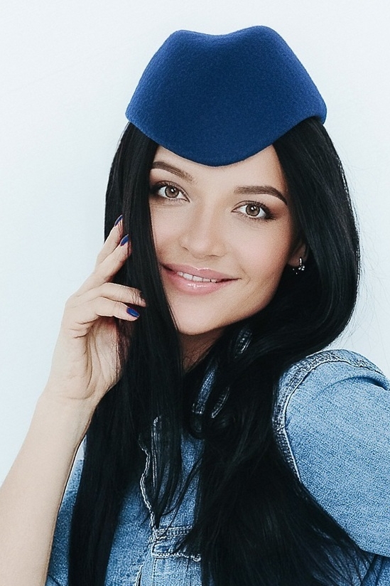 Синяя фетровая женская шляпка пилотка на девушке брюнетке в джинсовой рубашке
