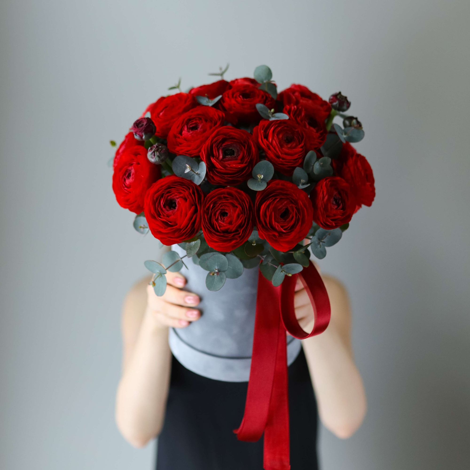 Красные ранункулюсы в шляпной коробке