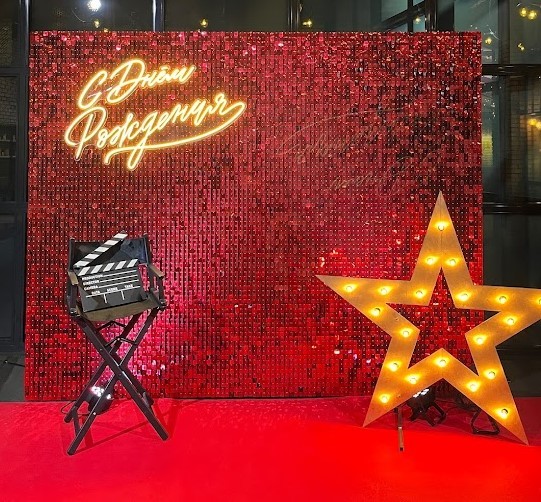 Красная фотозона с креслом режиссера и звездой