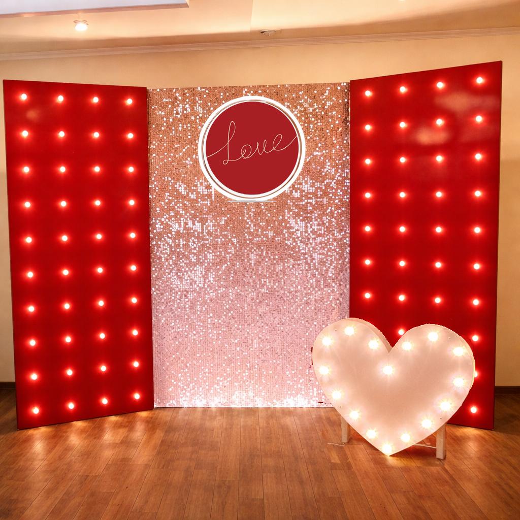 Фотозона из розовых пайеток с красными панелями с лампочками