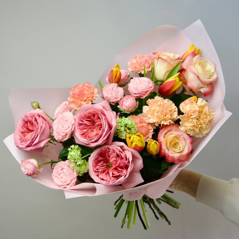 Яркий и свежий букет, сочетающий розовые розы, персиковые гвоздики, желтые тюльпаны