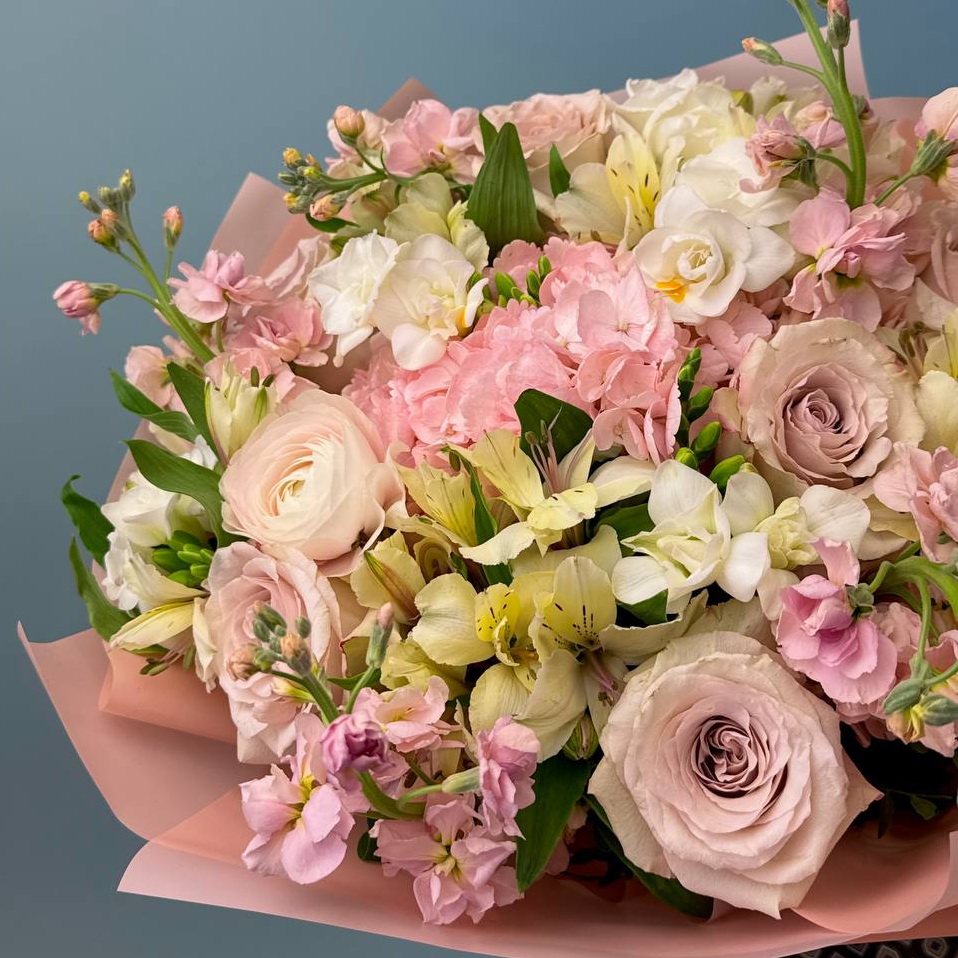 Восхитительный букет, сочетающий элегантные розы, воздушные гортензии, нежные фрезии и изящные альстромерии в мягких оттенках розового, белого и кремового