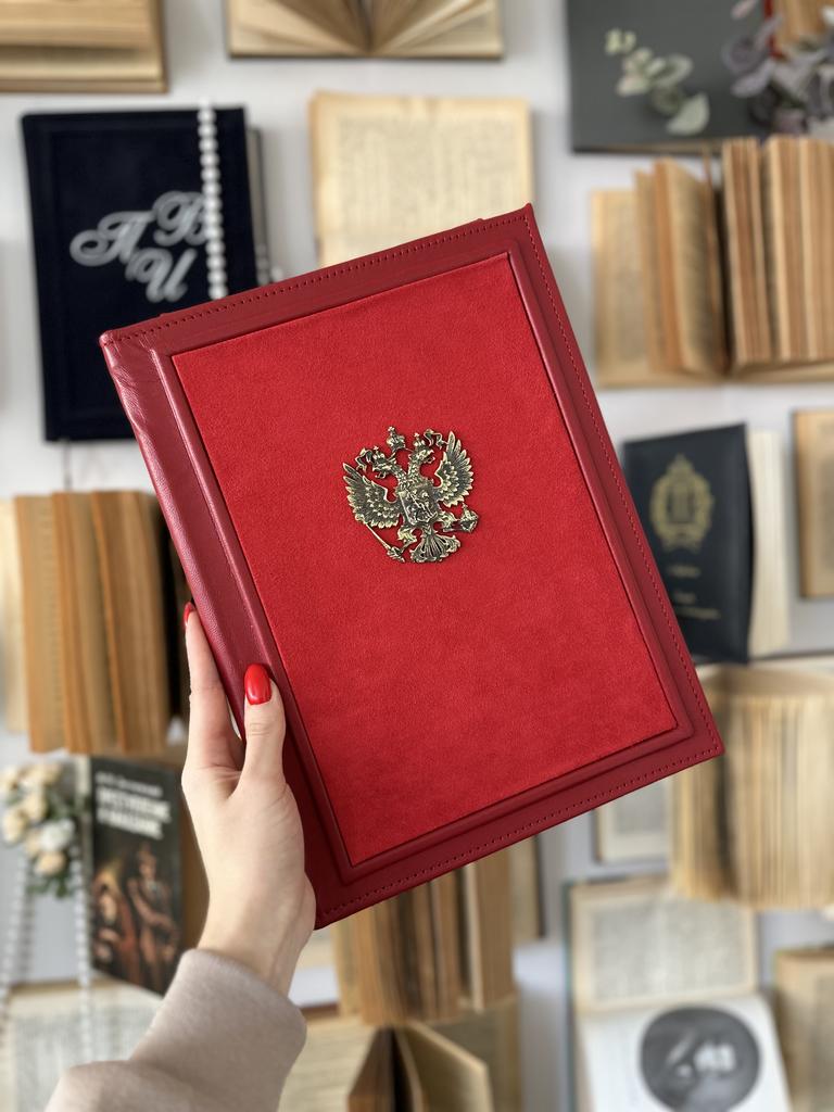 Папка в натуральной красной коже с красной алькантарой по центру и бронзовым гербом РФ. Роскошная комбинация текстур, официальный стиль.