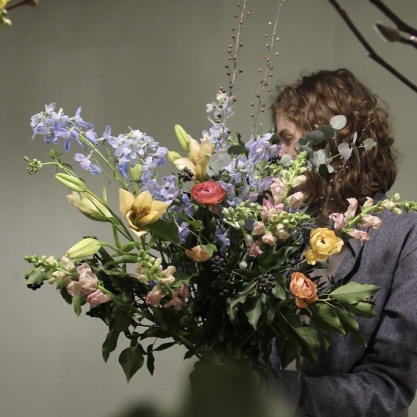 Нежный букет цветов с лютиками, дельфиниумом и лилиями вид 1