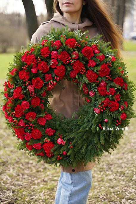 Круглый траурный венок из живых цветов " С зеленью, гвоздиками и ягодами"