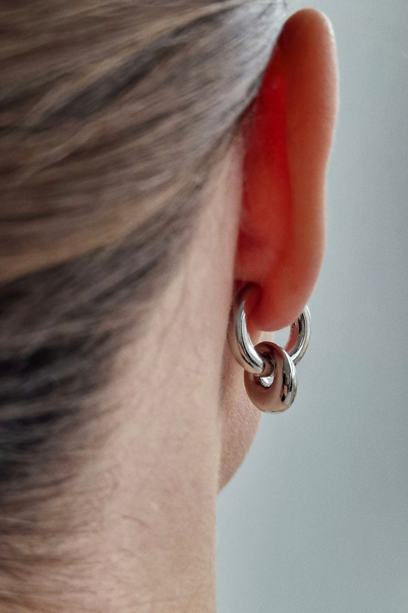 серебристые серьги конго с подвесками на женском ухе